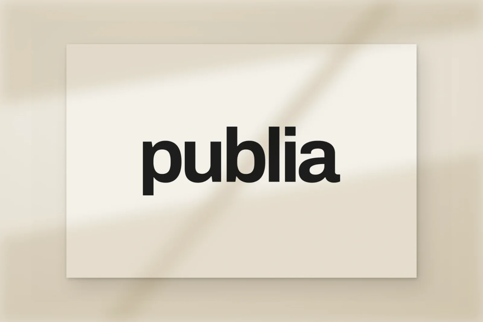 Publias ordbild, ”publia” i en kraftig svart grotesk, tryckt på ett papperskort i mjukt fönsterljus.